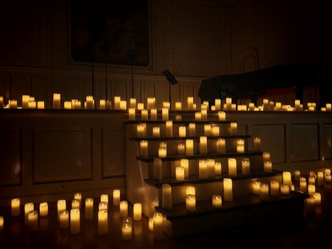 A dark room with steps illuminated by numerous flickering candles, creating a serene atmosphere.