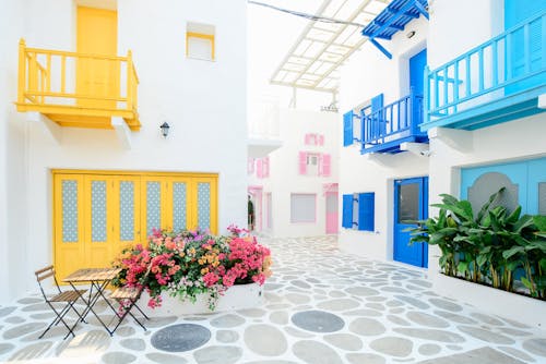 Архитектурная фотография трех зданий розового, синего и желтого цветов