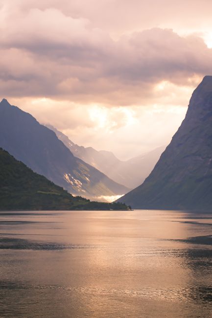 Captivating view of a Norwegian fjord under dramatic sunset skies.