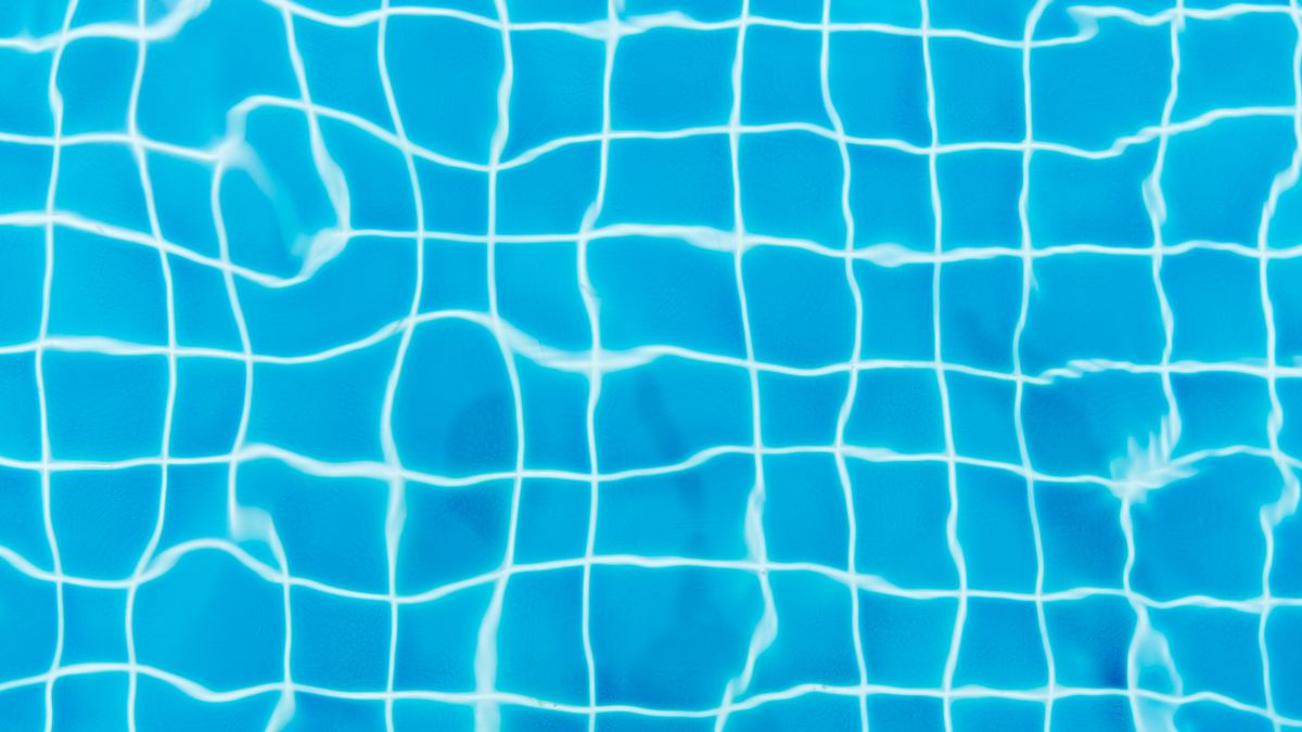 Vista de cima do revestimento azul de uma piscina — como remover calcário dos revestimentos Vista de cima do revestimento azul de uma piscina — como remover calcário dos revestimentos