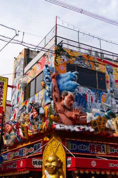 Vibrant Japanese storefront adorned with eclectic statues and colorful art in bustling city.