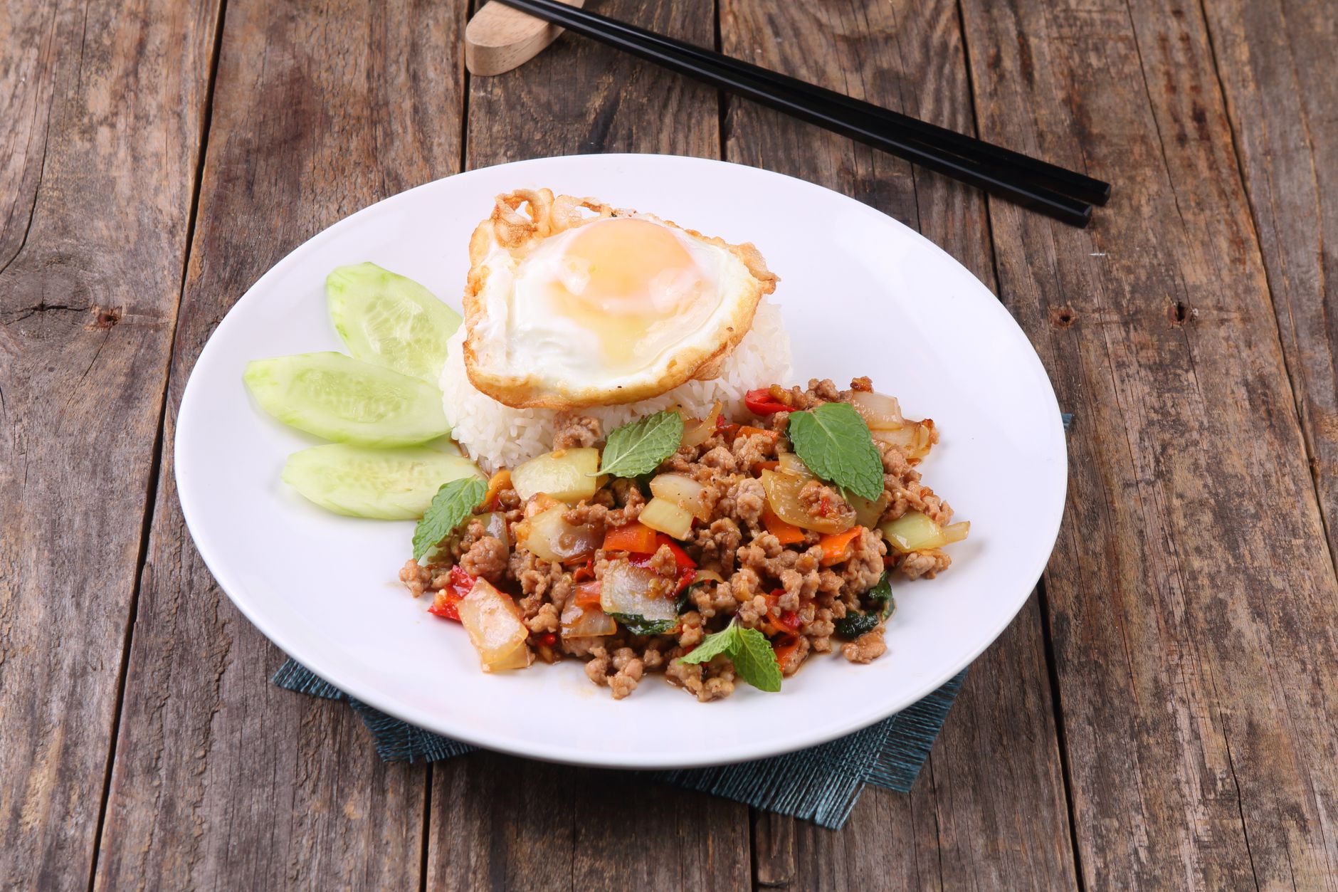 Thai Style Turkey with Fried Eggs on a plate garnished with fresh basil