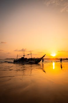 Beautiful sunset view with a fishing boat on the beach in Weligama, Sri Lanka.