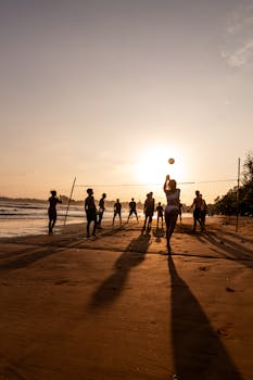 Group playing beach volleyball during a stunning sunset in Weligama, Sri Lanka.
