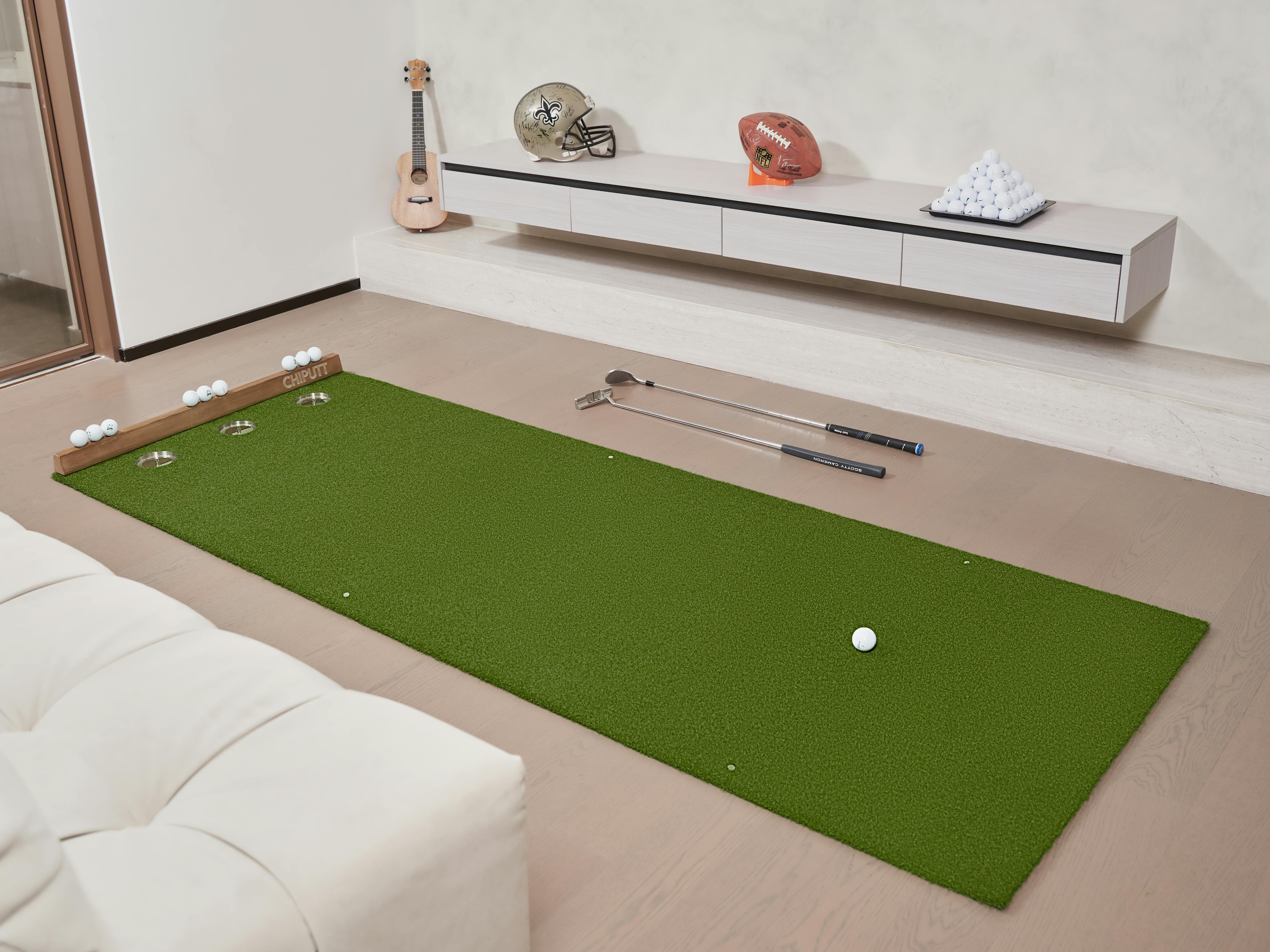 A cozy indoor setup showcasing a green putting mat with golf clubs and balls, ideal for practice and relaxation.
