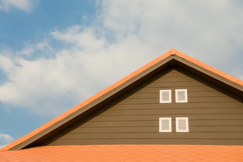 Techo Pintado De Naranja Y Gris Bajo El Cielo Nublado