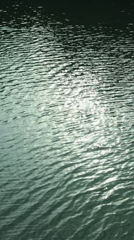 A serene view of water ripples reflecting sunlight, creating a calming abstract pattern.