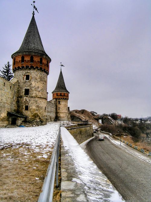 Free Historic castle towers overlooking snow-dusted landscape in winter. Stock Photo