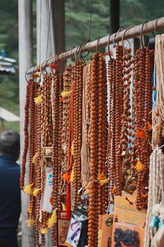 A display of Rudraksha prayer beads hanging at an outdoor market, showcasing vibrant colors and textures.