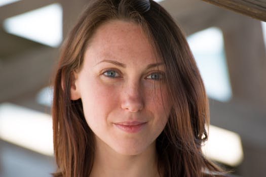 Close-up portrait of a smiling young woman with natural lighting and soft background.