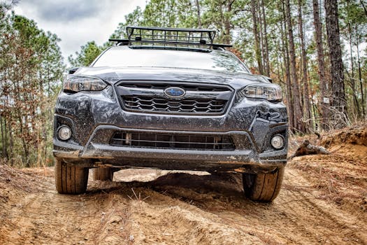 A rugged off-road vehicle traversing a sandy path in a dense forest setting.