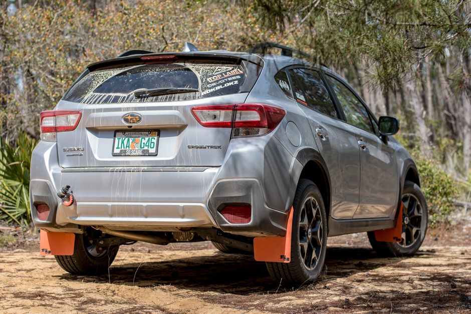 A silver SUV with Florida plates parked in a forest, ready for adventure.