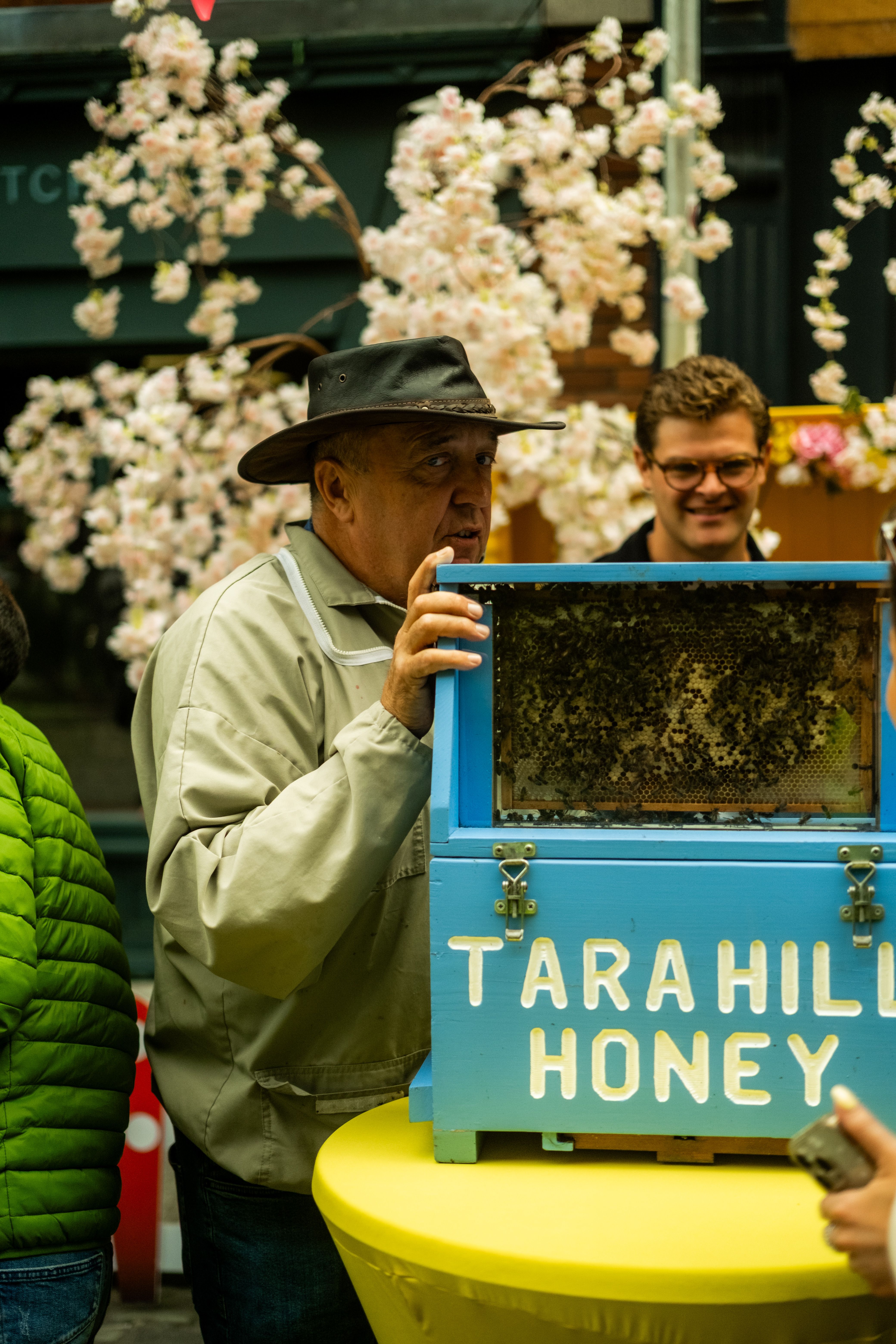 Beekeeper displays honey and bees at Dublin street market.