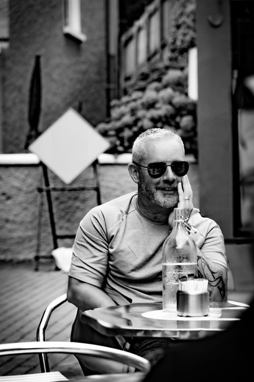 Free Black and white portrait of a man sitting outdoors at a cafe in Kinsale, Ireland. Stock Photo