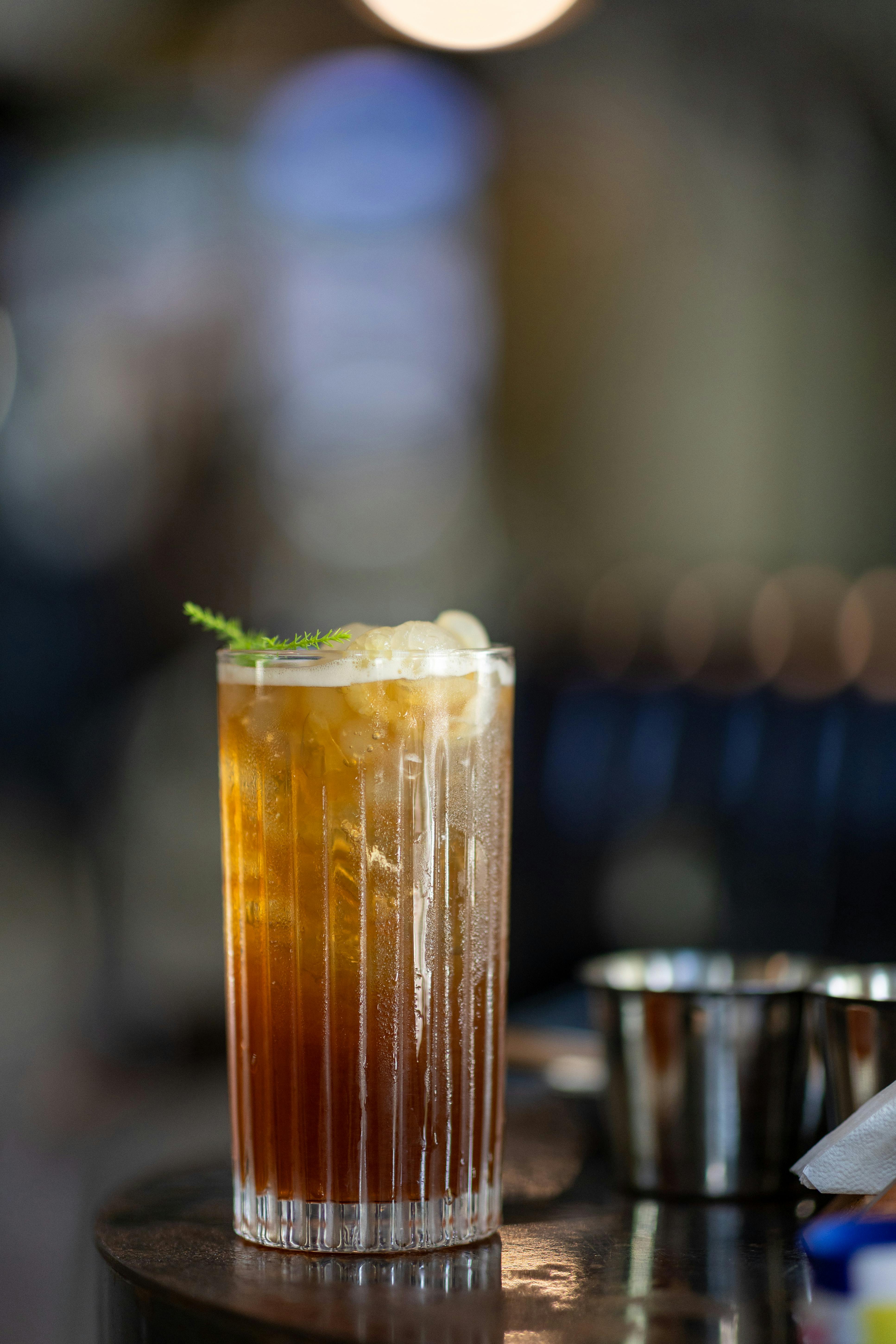 Free Chilled iced tea with ice cubes in a tall glass at a cozy cafe setting. Stock Photo