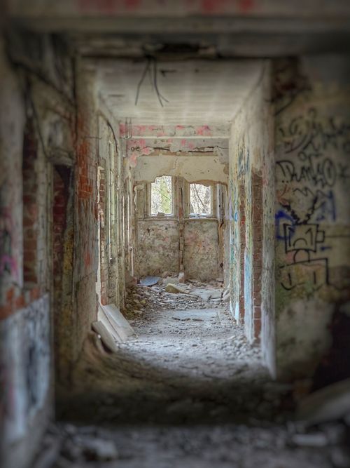 Free Explore the crumbling corridor of an abandoned graffiti-covered building. Stock Photo