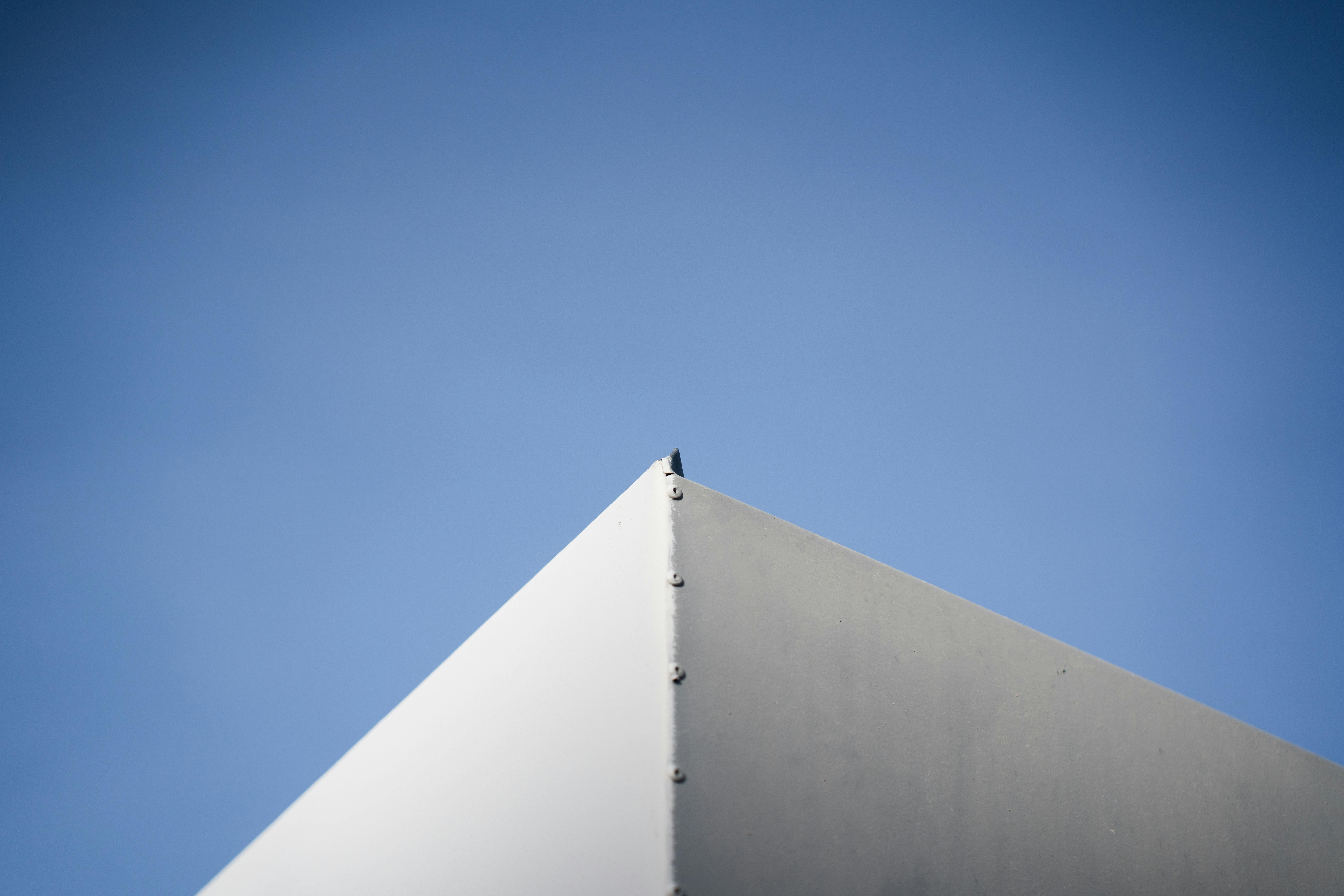 Gratis Et minimalistisk arkitektonisk hjørne mod en livlig blå himmel, der fremviser enkelhed og moderne design. Lagerfoto