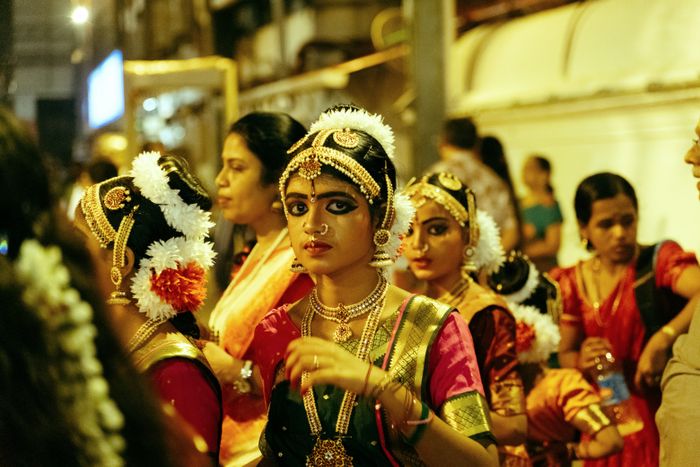 Bharatanatyam dancers in traditional attire performing together at night