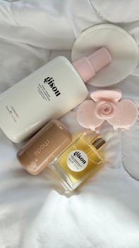 An artistic arrangement of luxury beauty products on a white fabric background, perfect for fashion or self-care themes.