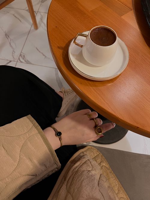 Free Hand with rings on a coffee table with a cup in a cozy café setting. Stock Photo