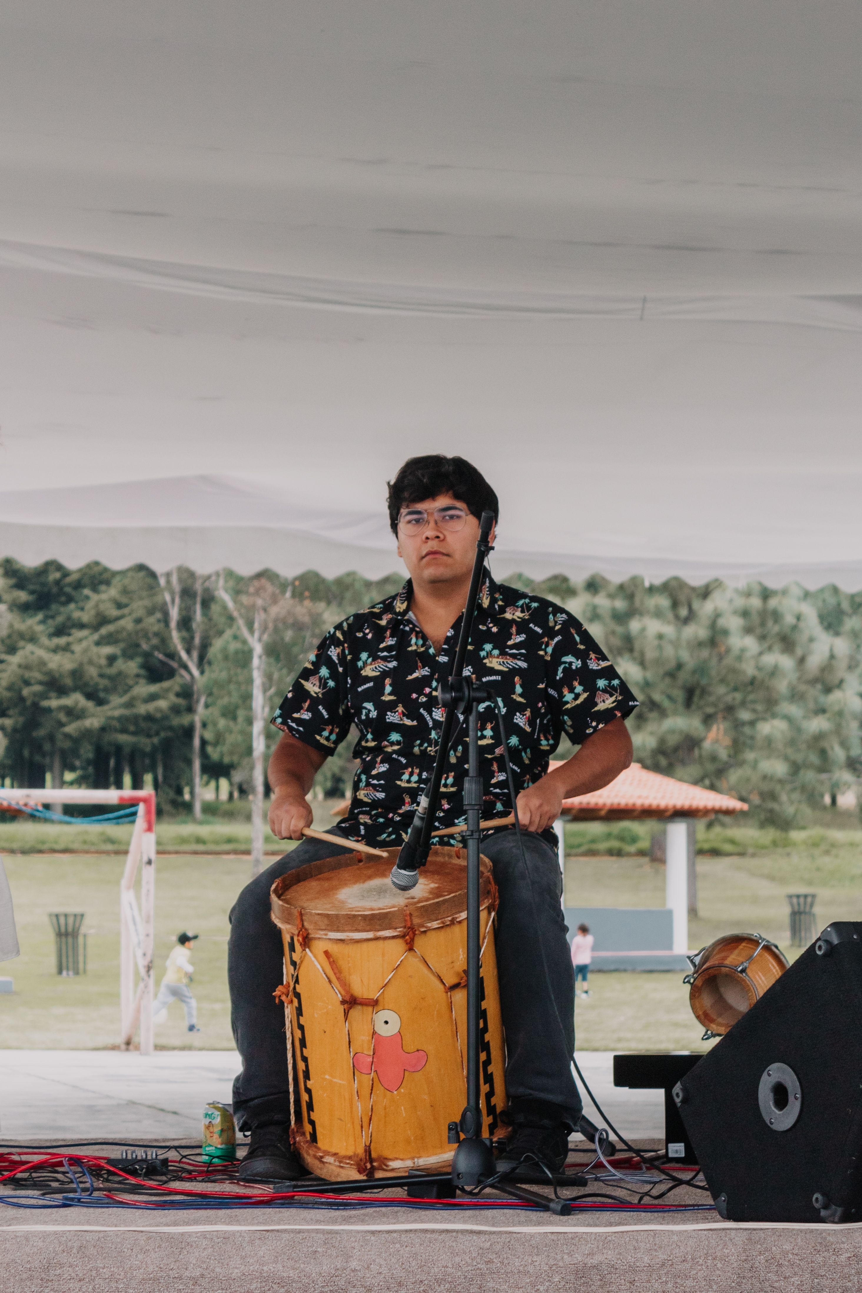 Man Playing Traditional Drum in Park Setting · Free Stock Photo