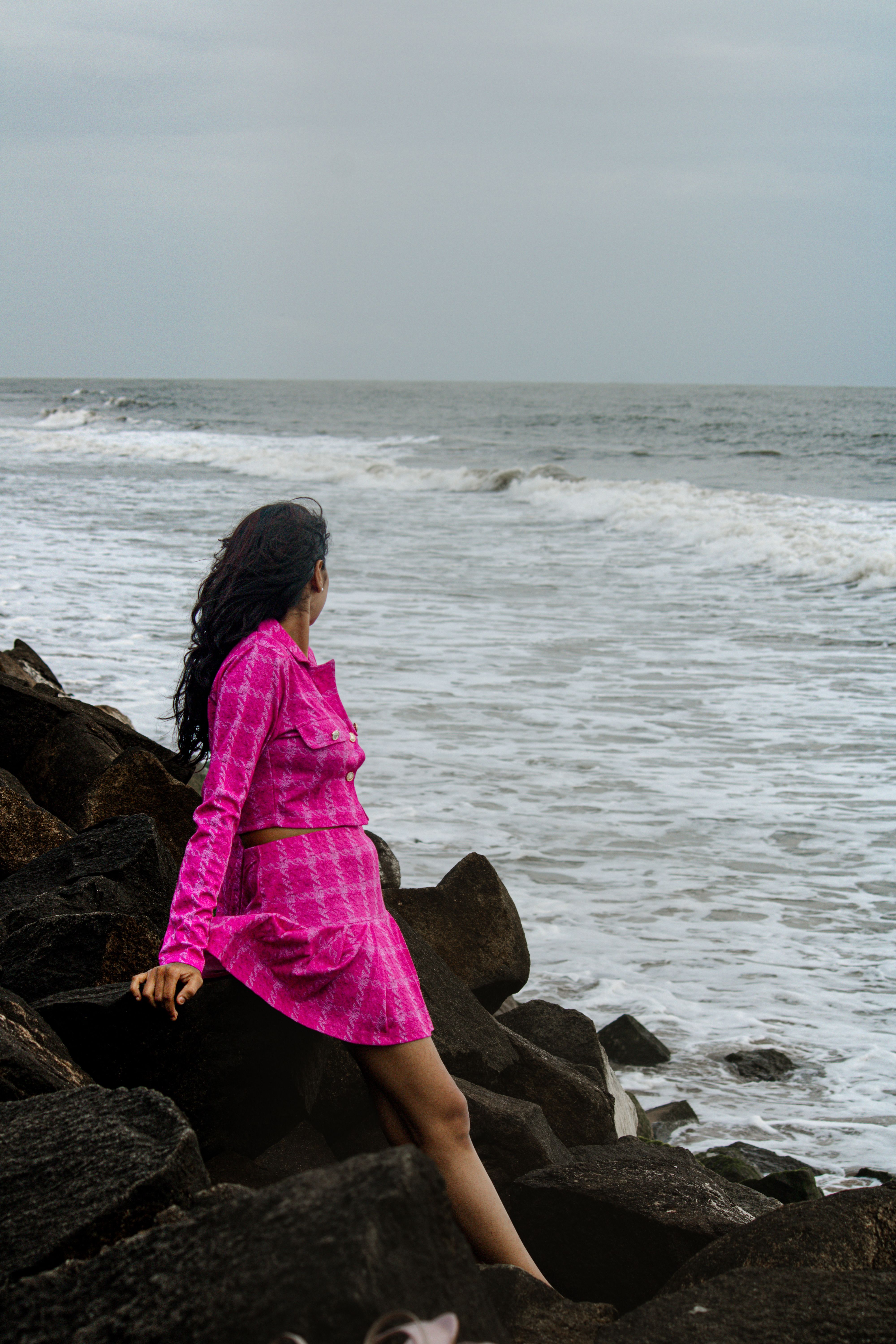Woman in Pink Dress Sitting by the Ocean · Free Stock Photo