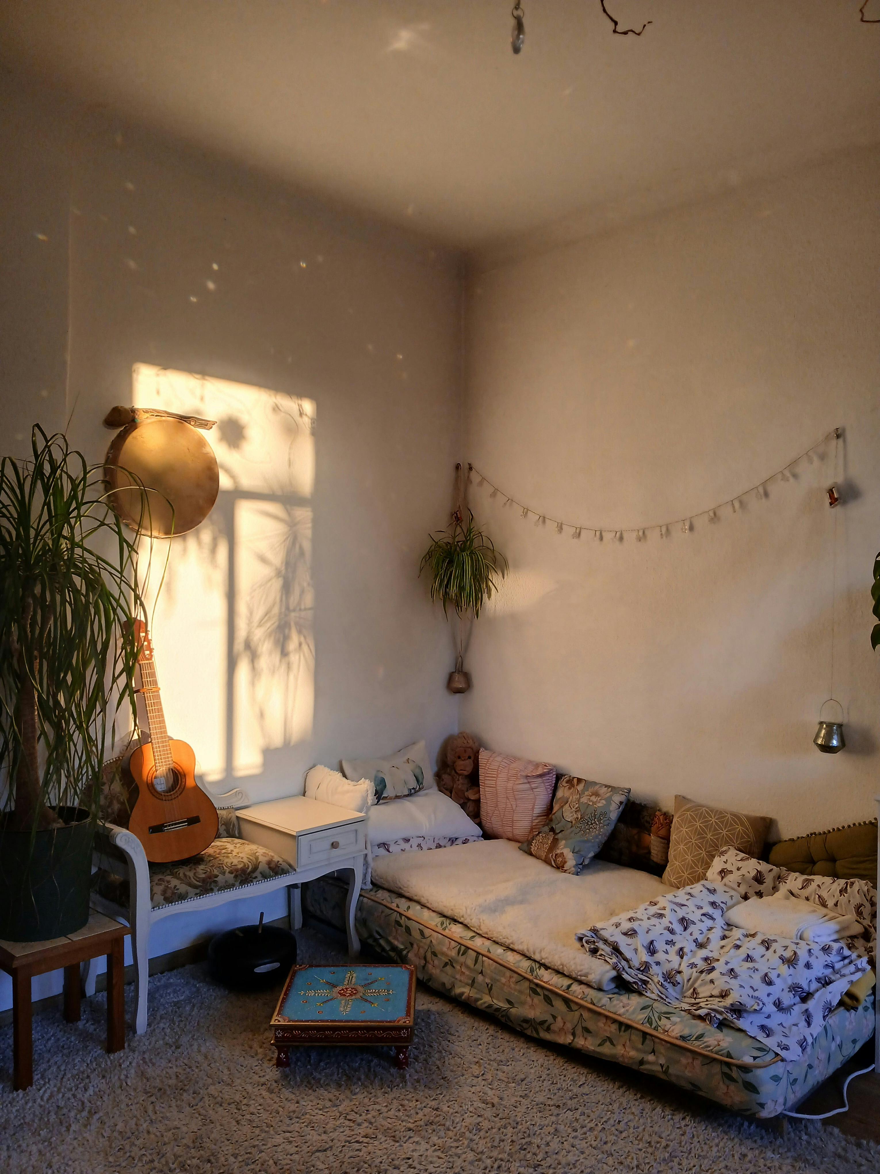 A warm, inviting bohemian living room with a guitar and plush seating, perfect for relaxation.
