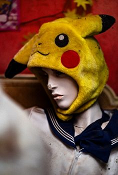 Mannequin dressed in a Pikachu-themed hood in an old, nostalgic setting.