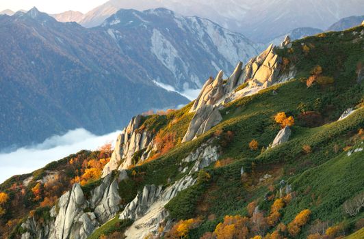 Breathtaking view of autumn foliage and jagged peaks in the Japanese Alps.