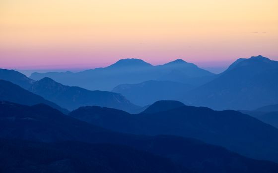Beautiful sunset over layered mountain ranges in Italy's Dolomites.