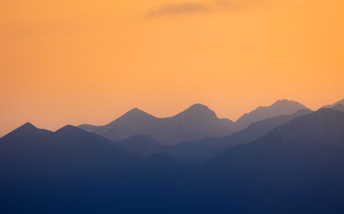 Free Stunning silhouette of Bavarian mountains against an orange sunset sky. Stock Photo