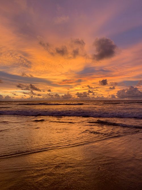 Free Breathtaking sunset over Phuket beach with vivid hues reflected on the water's surface. Stock Photo