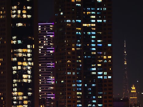 Skyscrapers at night with lights on, showcasing urban life in a vibrant cityscape.