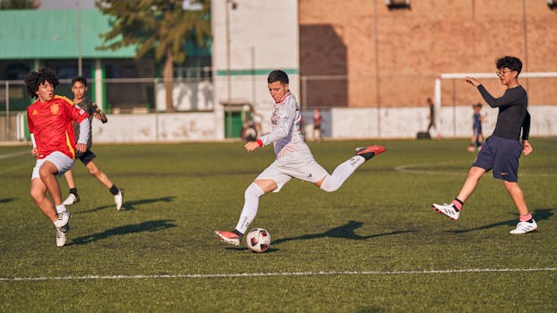 Energetic soccer match with teenagers competing on a sunny outdoor field.