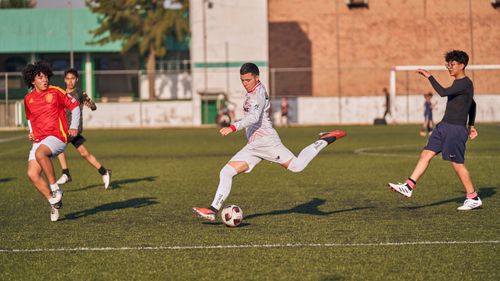 Free Energetic soccer match with teenagers competing on a sunny outdoor field. Stock Photo