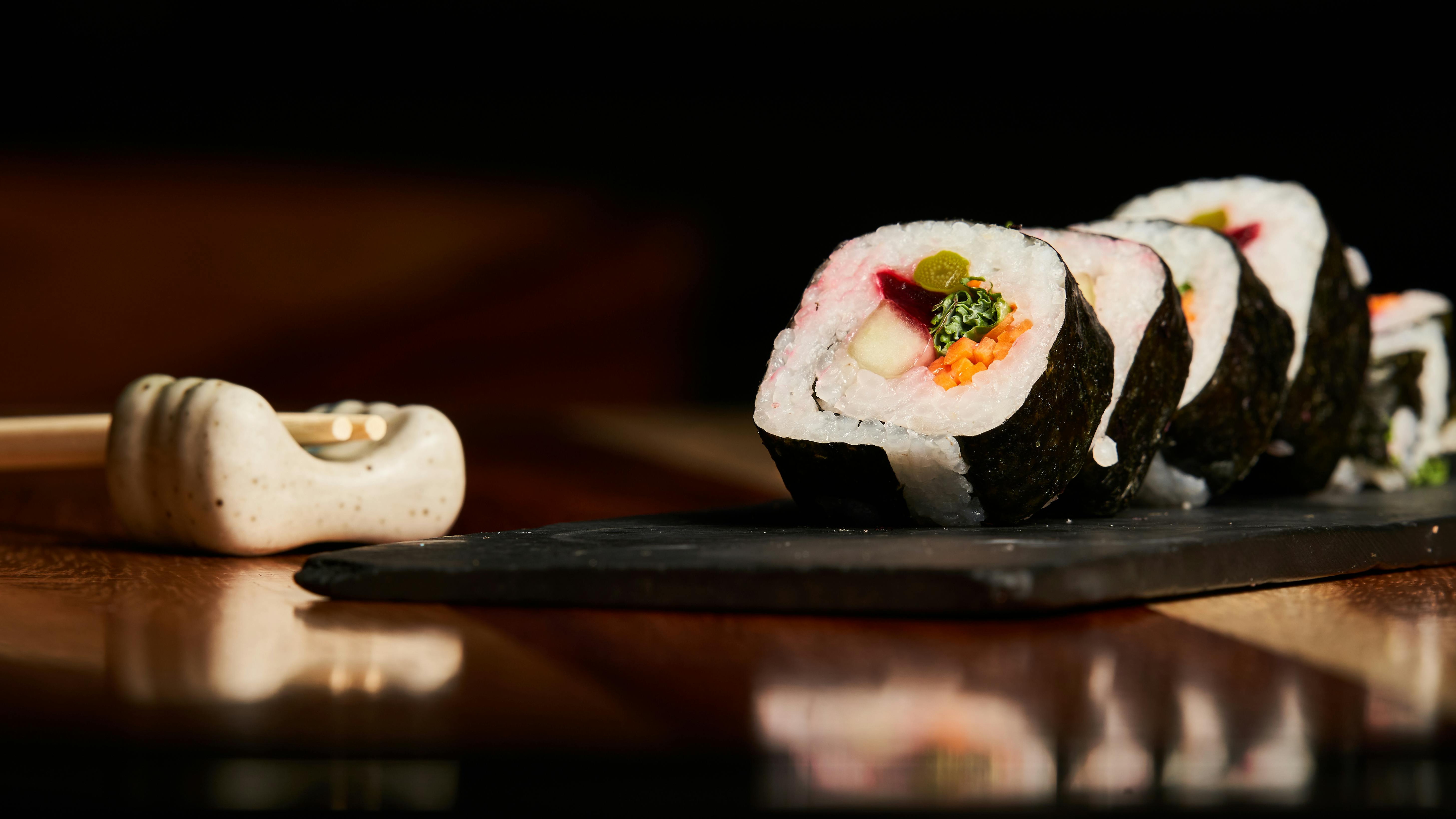 Appetizing vegetarian sushi rolls with fresh ingredients served on a slate. Perfect for food lovers.
