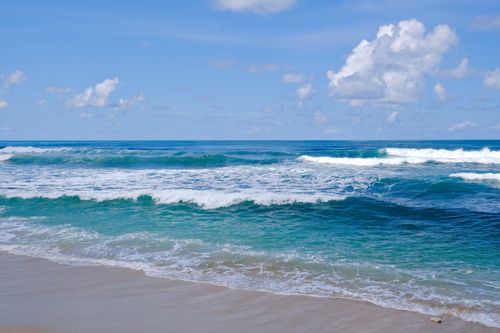 Free A stunning beach scene with vibrant ocean waves under a clear blue sky on a sunny summer day. Stock Photo