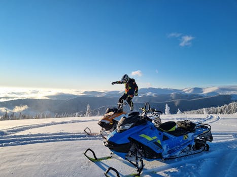 A thrilling snowmobile adventure on a snowy mountain during a bright winter day.