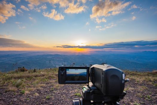 Capturing a breathtaking sunset over the mountains in Minas Gerais, Brazil, with a professional camera setup.