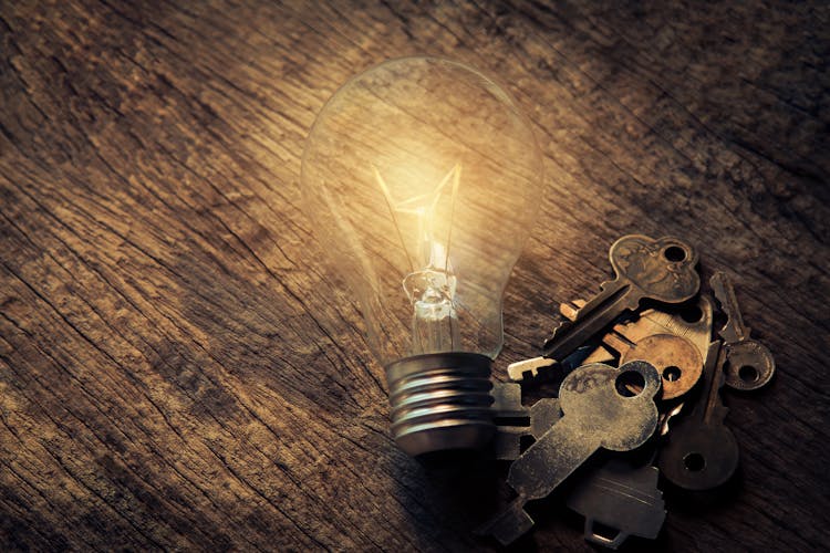 Light Bulb And Keys On Table