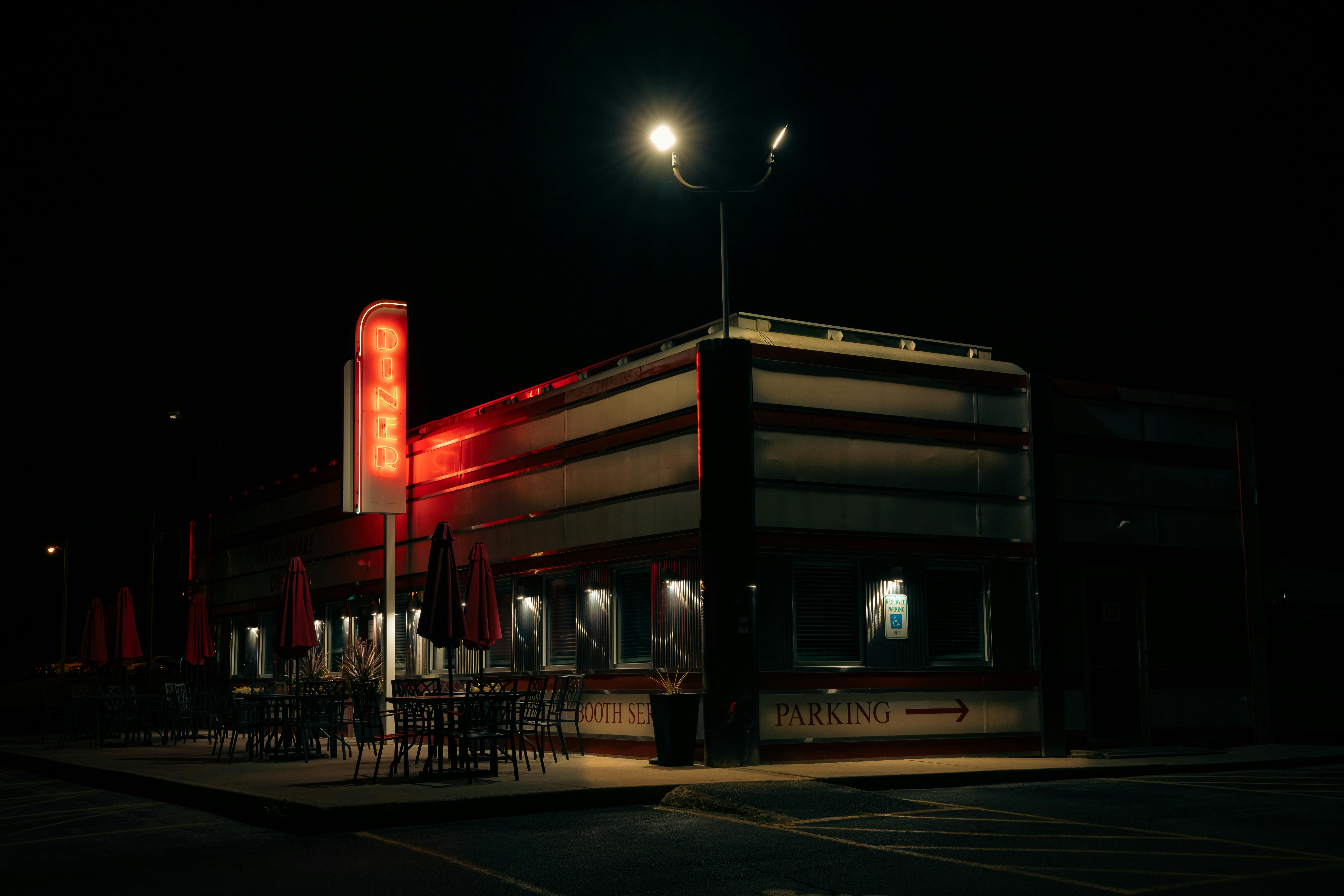 A classic American diner illuminated by a neon sign during the night, creating a nostalgic ambiance.