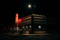 A classic American diner illuminated by a neon sign during the night, creating a nostalgic ambiance.