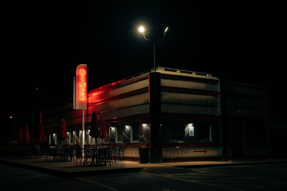 A calm night view of a Freddy's Frozen Custard restaurant with an empty parking lot and streetlights