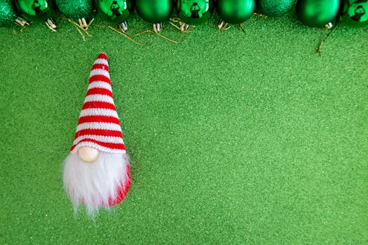 Colorful Christmas gnome and ornaments on textured green backdrop.