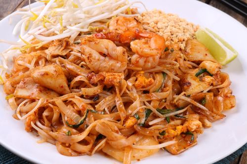 Free Colorful plate of Thai shrimp pad Thai with lime, peanuts, and bean sprouts. Stock Photo