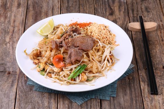 Rice noodles with sliced beef, bean sprouts, carrot, scallion, lime, peanuts and chili powder