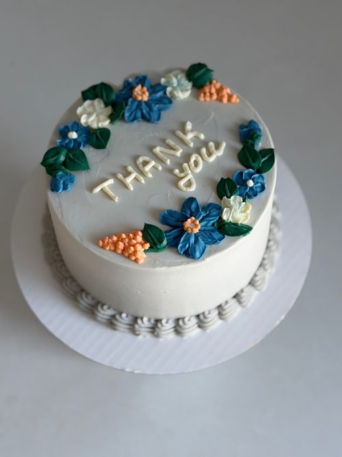 Free A beautifully decorated cake with floral icing and 'Thank You' message, perfect for celebrations. Stock Photo