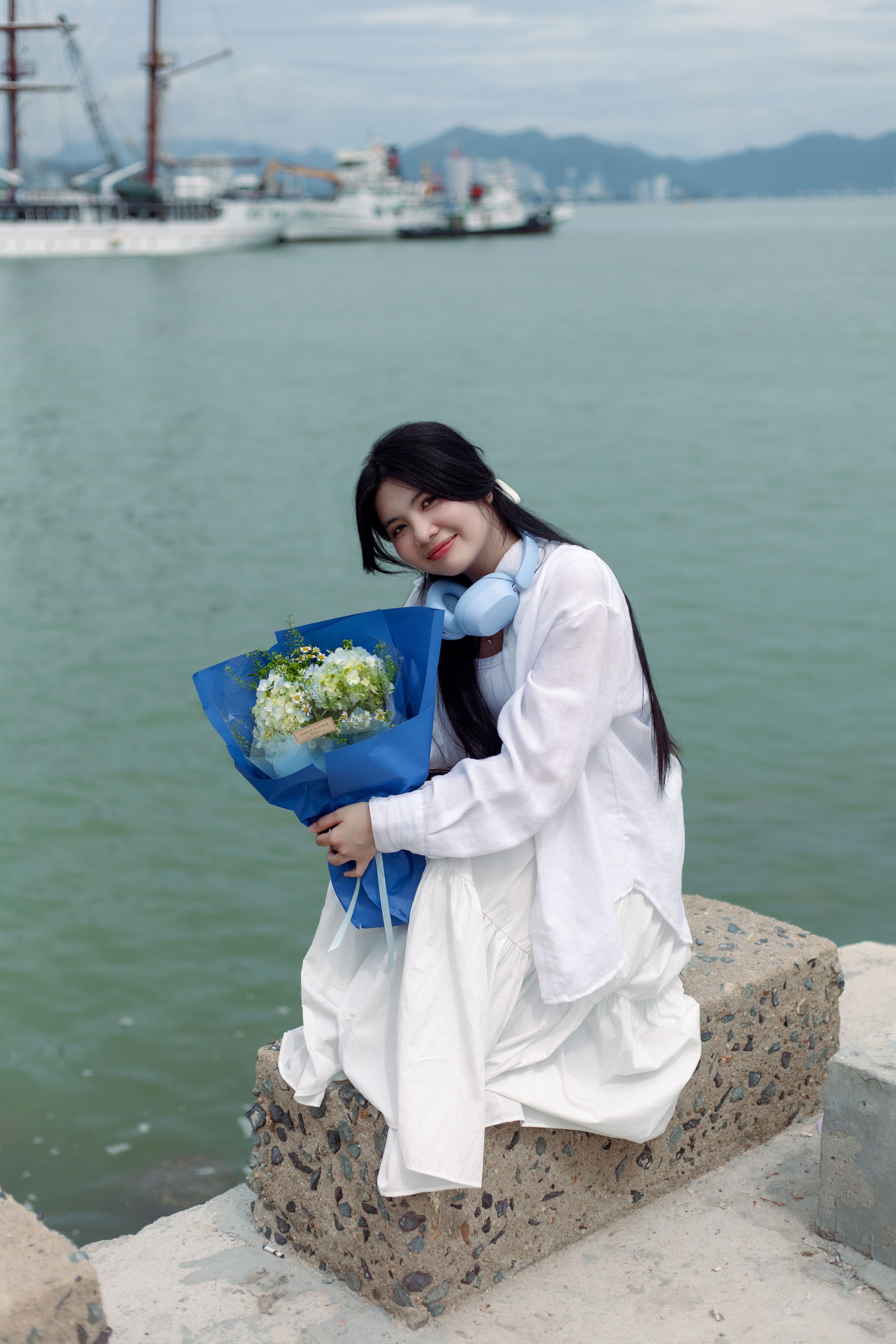 Woman with Bouquet by the Waterfront · Free Stock Photo
