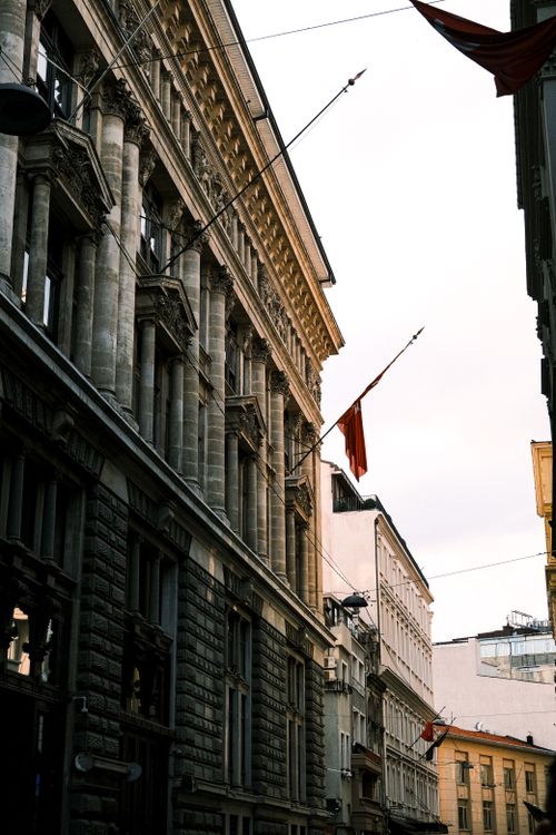Free Urban cityscape featuring classic architecture and flags on a street with symmetrical facades. Stock Photo