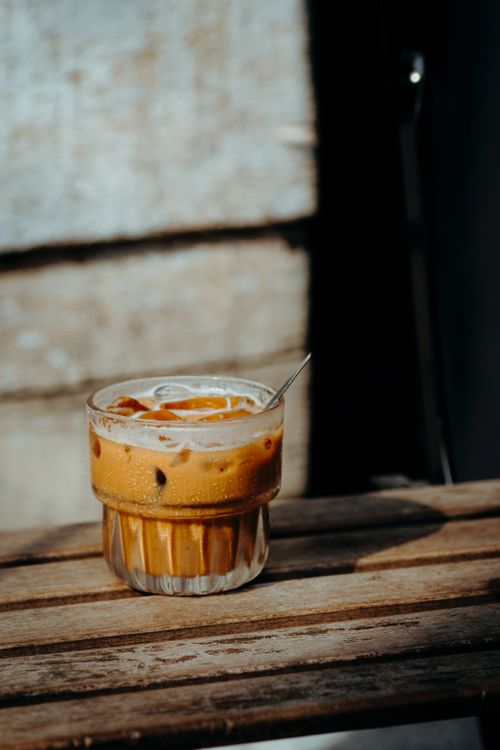 Free A refreshing iced coffee garnished with cream in a cozy, rustic environment. Stock Photo